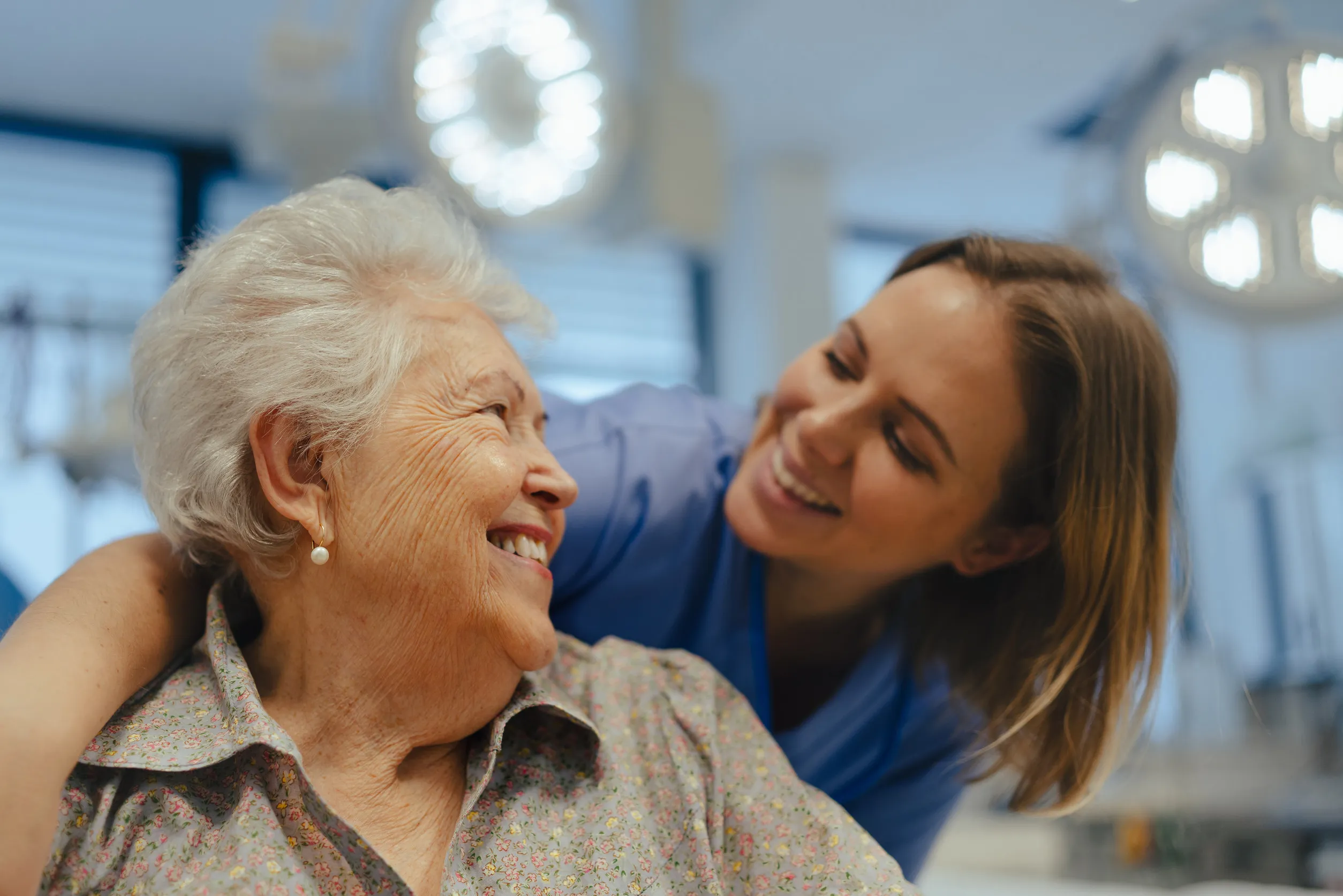 Portrait of nurse and senior patient talking in hospital corridor